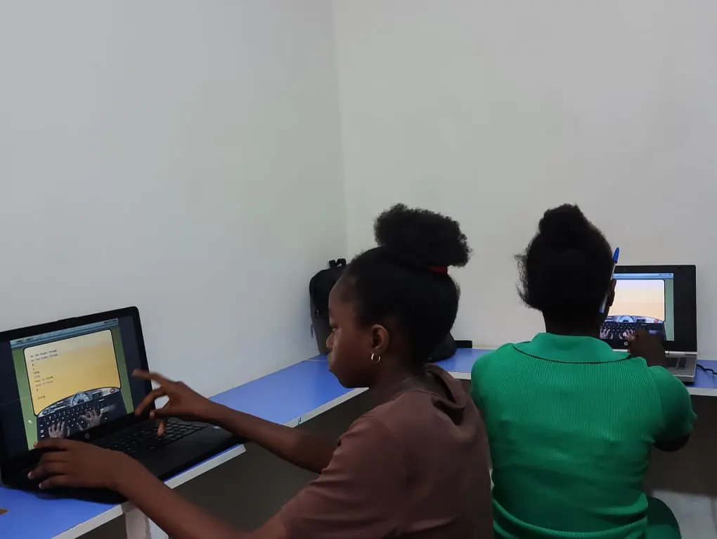 Students practising typing mastery on laptops at HCS Abuja